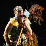 Image of man on stage holding an axe