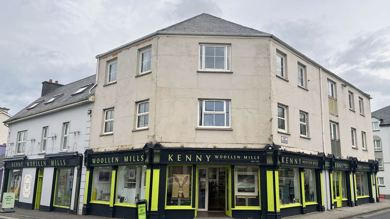 Black and yellow painted shop front with and windows and an open door