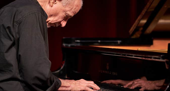 Marc Copland playing a piano.