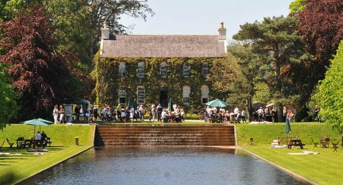 Festival of Gardens & Nature 2026, view across a man made square pond looking at an old house in the distance.