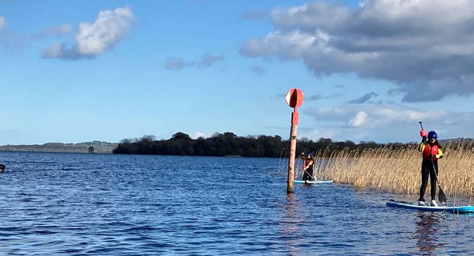 Two people out on the water enjoying stand-up paddle boarding