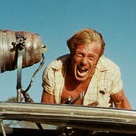 A screaming man on top of a vehicle.