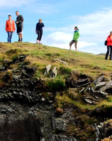 A small group of people standing on a cliff 