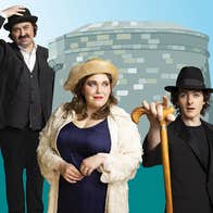 Ulysses aWake at James Joyce Tower, 2 men dressed in dark clothes either side of a smiling woman in fancy coat and hat.