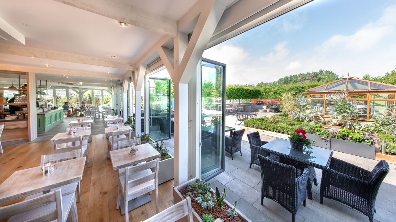 The interior of a café with doors open onto an outdoor terrace