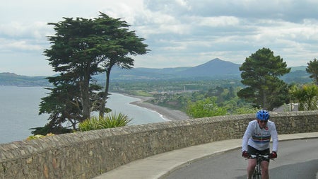 Irish Cycling Safaris cyclist on Killiney Hill with a view of the Dublin Mountains and the sea