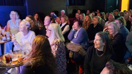 An audience laughing in a comedy club