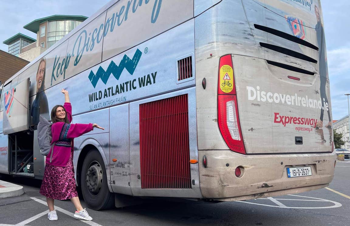 Girl standing in front of a Wild Atlantic Way Expressway bus.