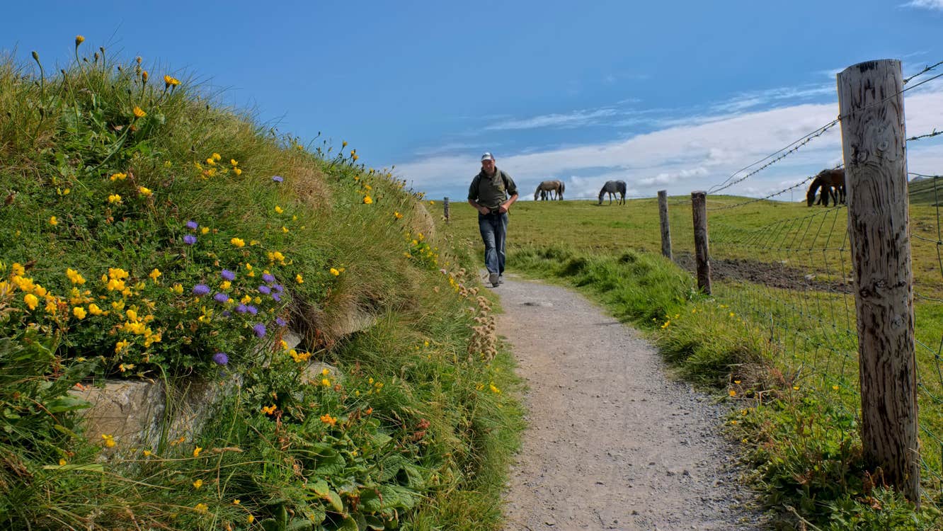 Image of a man walking along the Doolin Cliff Walk in County Clare