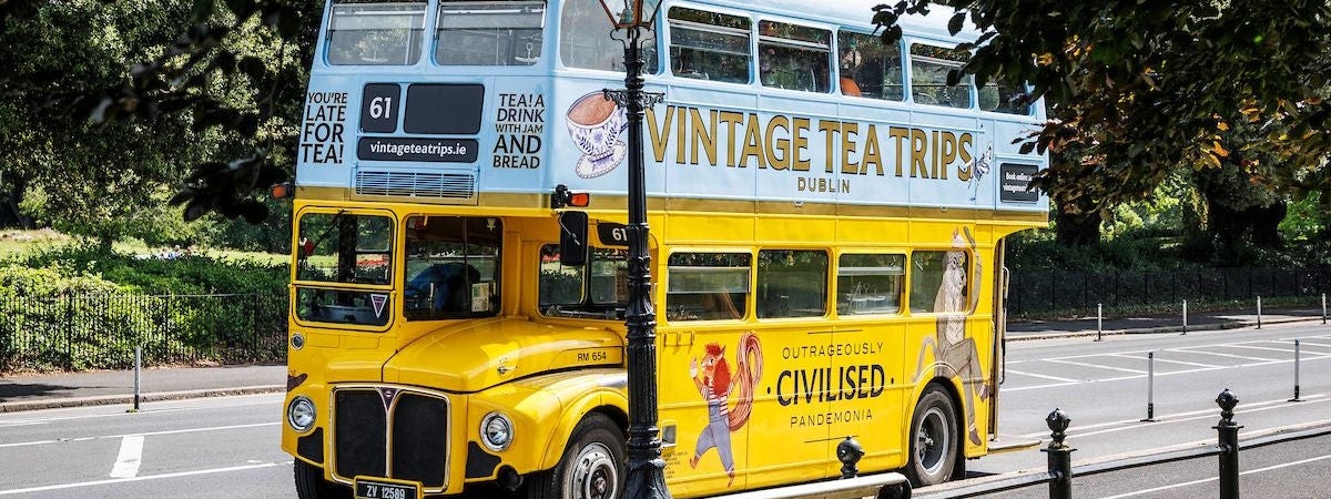A yellow and blue vintage double decker bus