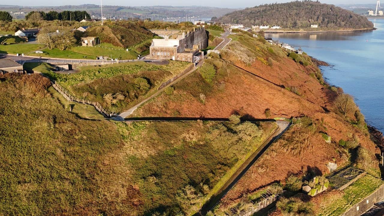 Aerial view of fort with a walking path running down to the coast