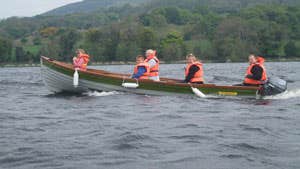 A Shannon Boat Hire lake boat on the water with paddling passengers