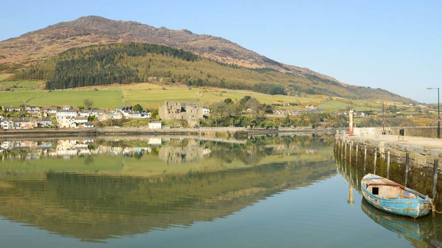 A boat at the harbour at Carlingford Lough with a backdrop of mountains