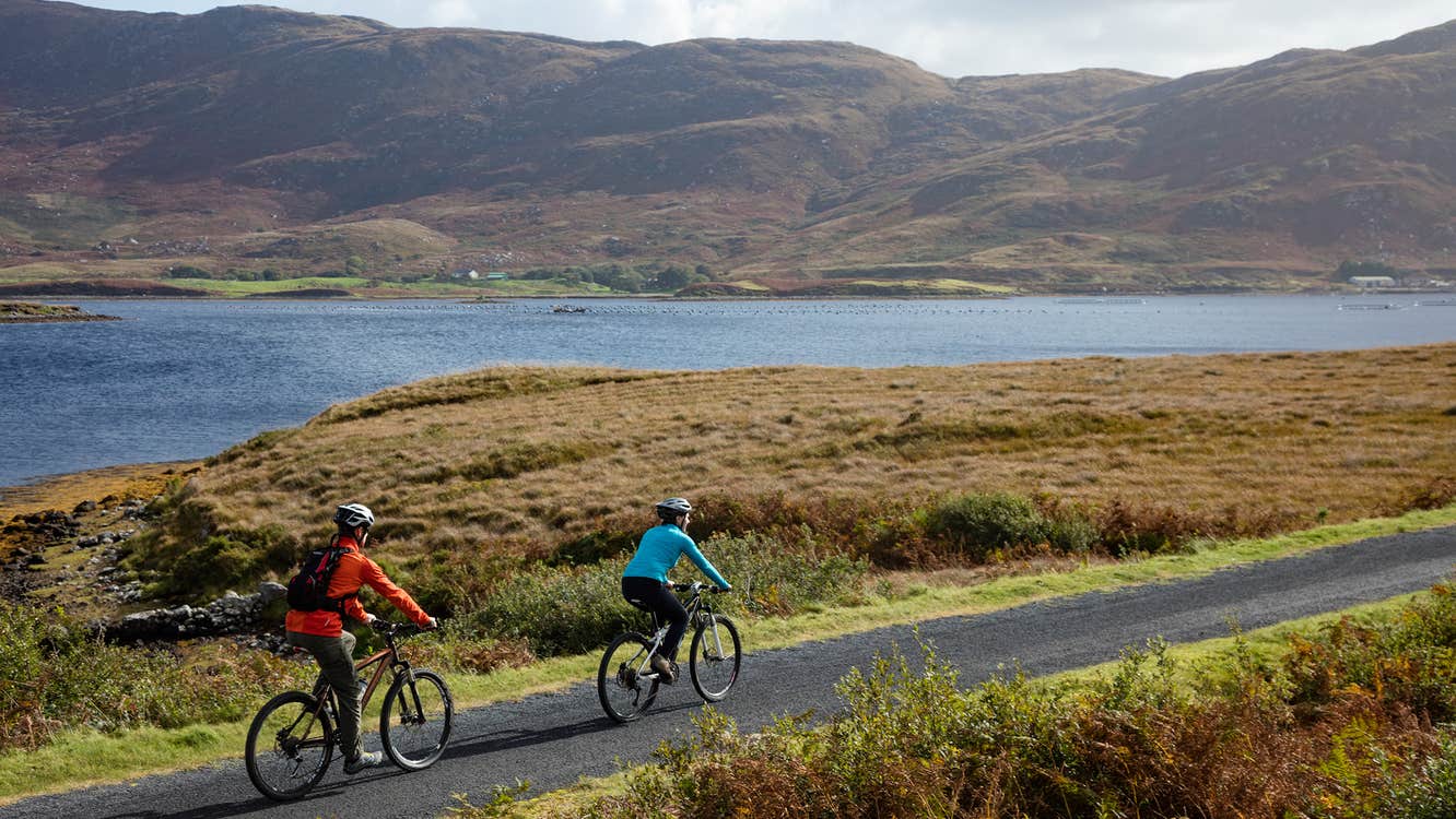 Cyclists by the water on a sunny day