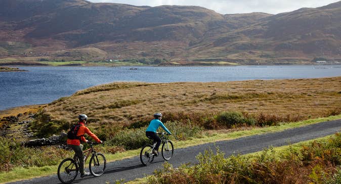 Cyclists by the water on a sunny day
