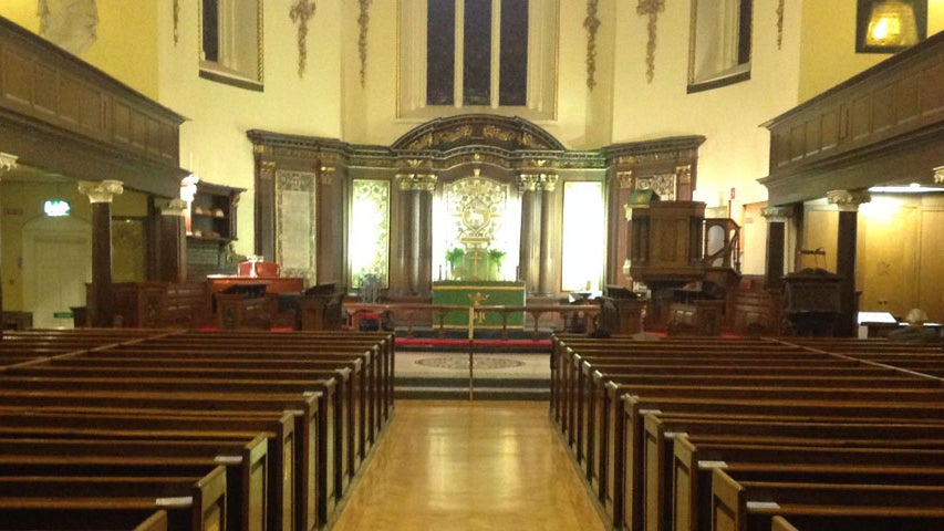 An aisle with pews leading up to an altar