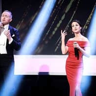 Gods, Monsters and Opera! Lú Festival of Light. A man and woman in evening dress holding mics, singing.
