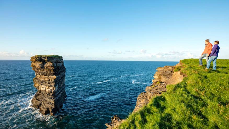 Two people admiring the views of the sea stack at Downpatrick Head