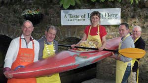 People holding up a woman in a kayak at Lough Derg Watersports