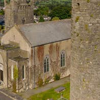 A church beside a round tower overlooking a town