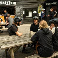 People sitting at a picnic bench having coffee