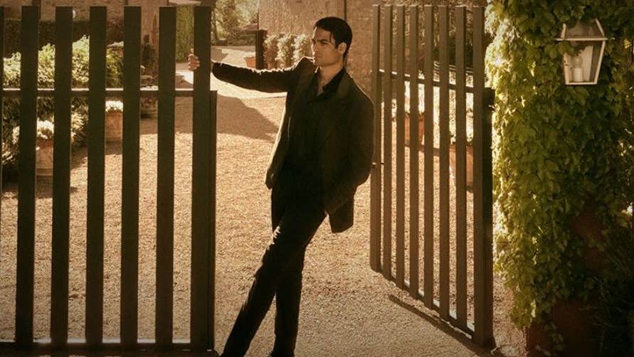 A man is swinging from a large gate