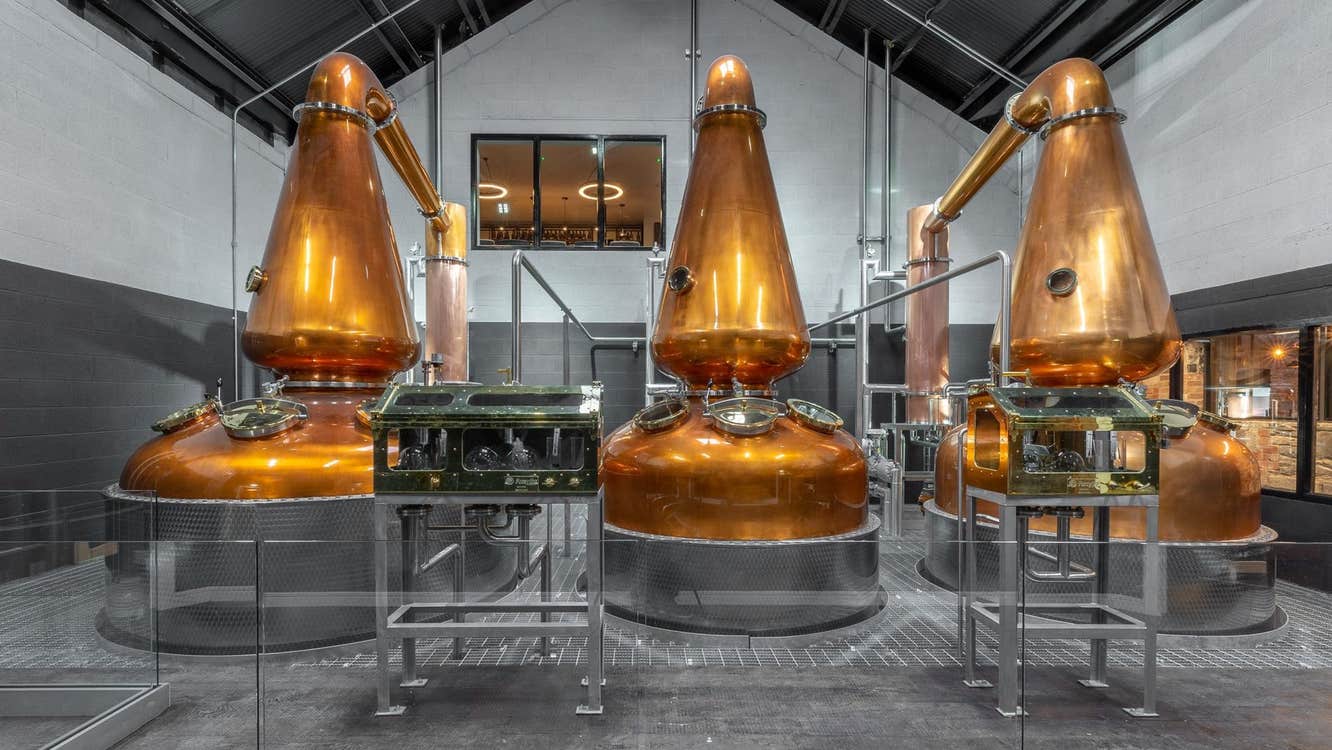 Three large copper stills in a distillery