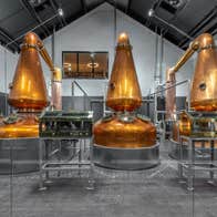 Three large copper stills in a distillery