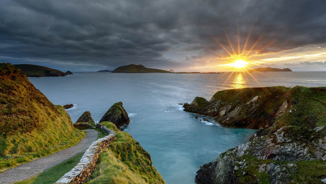 A winding road with coastal view as the sun goes down