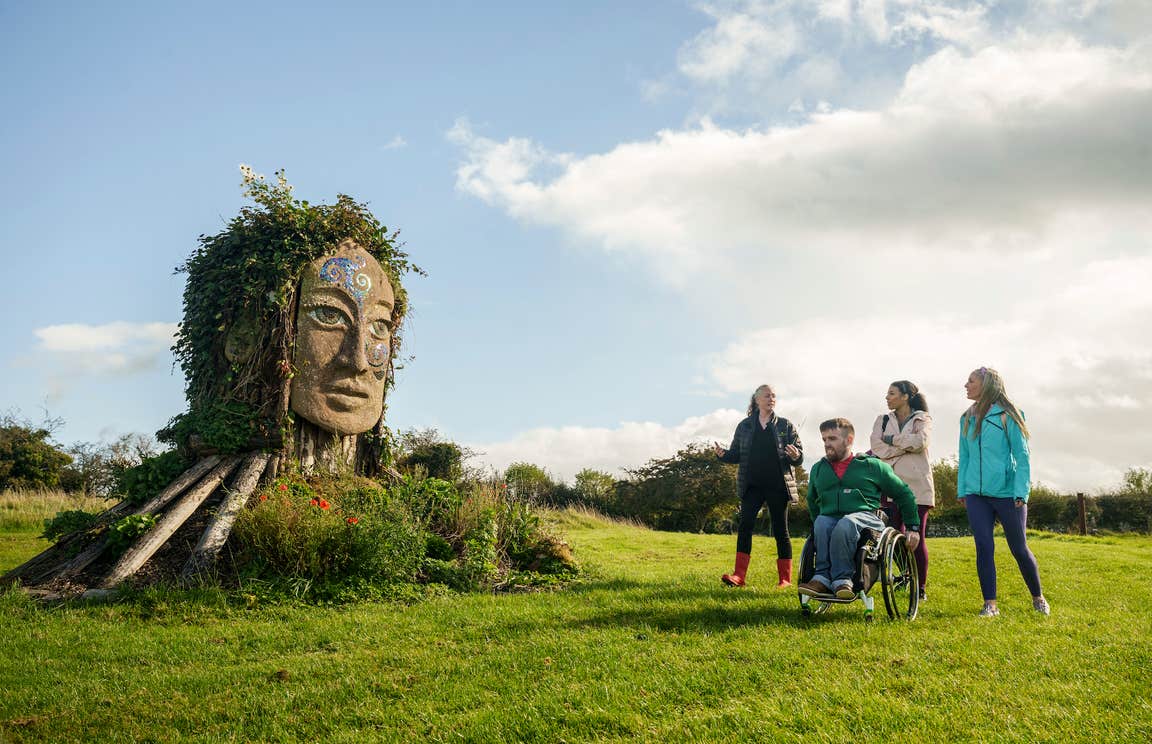 Three people receiving a tour of Hill of Uisneach in County Westmeath.