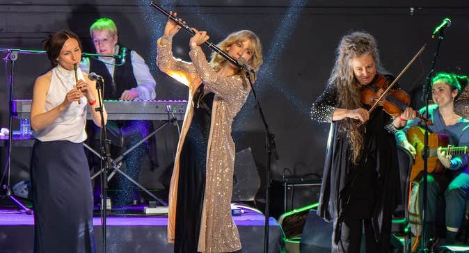 Women on a stage playing musical instruments