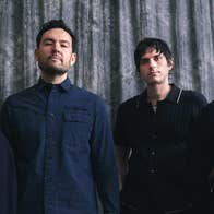 4 serious looking people in a line, dressed in dark clothes.