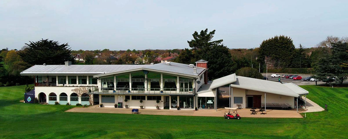 Exterior of the clubhouse from a height with a red golf buggy outside