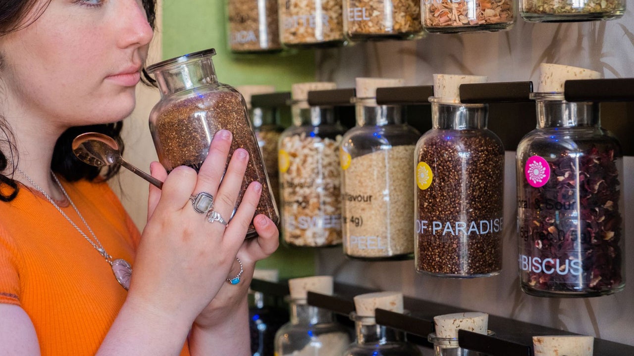 A lady smelling from the jar of the botanicals used to make the gin at Stillgarden Distillery
