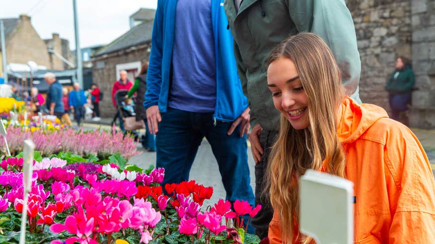 Young woman browsing flowers at The Milk Market in Limerick.
