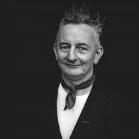 Writer & theatre maker Little John Nee, a smiling man with small neckerchief around his neck