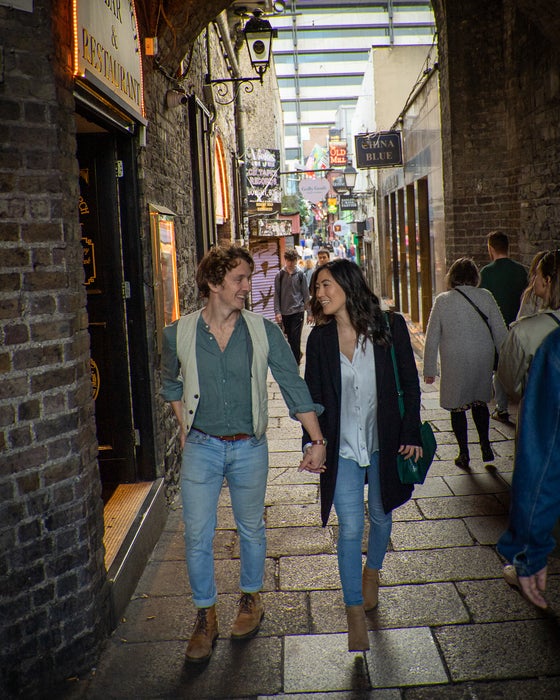 A couple walking through the Temple Bar archway in Dublin city