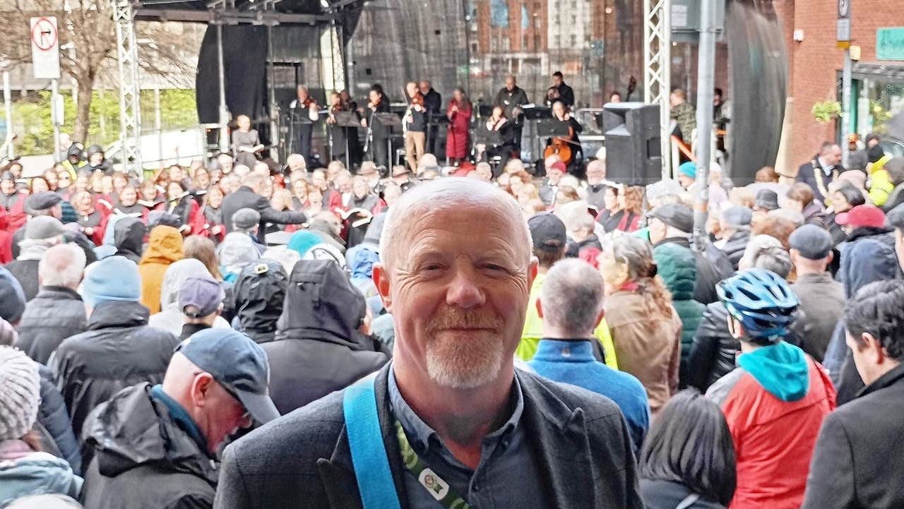 Tour guide David standing in front of musicians on a stage