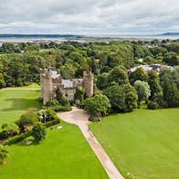 Malahide Castle and Gardens aerial view of the castle with Malahide Estuary in the distance