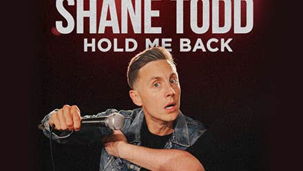 Shane Todd - Hold Me Back, a man with questioning expression is holding up a mic horizontally in front of him.