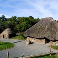 A high cross and ancient stone settlements at the Irish National Heritage Park in County Wexford.