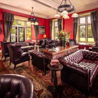 A seating area in a bar with large leather couches and tables