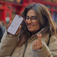 A person holding a phone up so that an app is visible on the screen