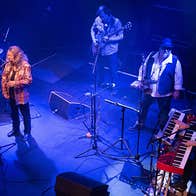 Looking down on a band playing on a small stage, lit with blue light