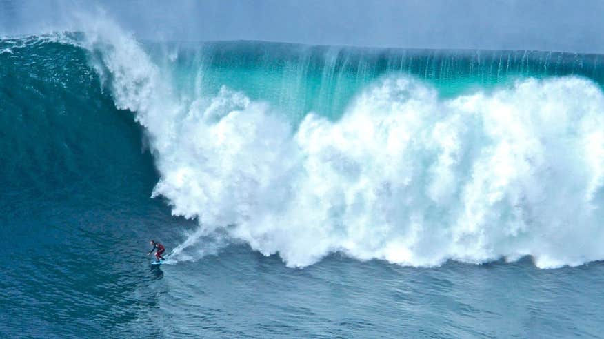 Surfer with a massive wave behind them in Sligo