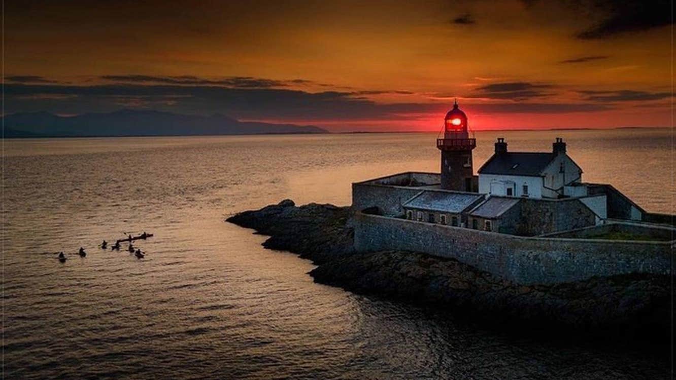 A view of Fenit Lighthouse at sunset with Wild Water Adventures