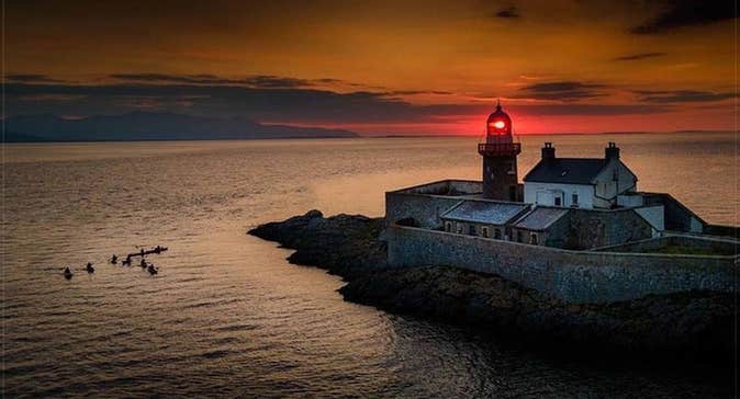 A view of Fenit Lighthouse at sunset with Wild Water Adventures