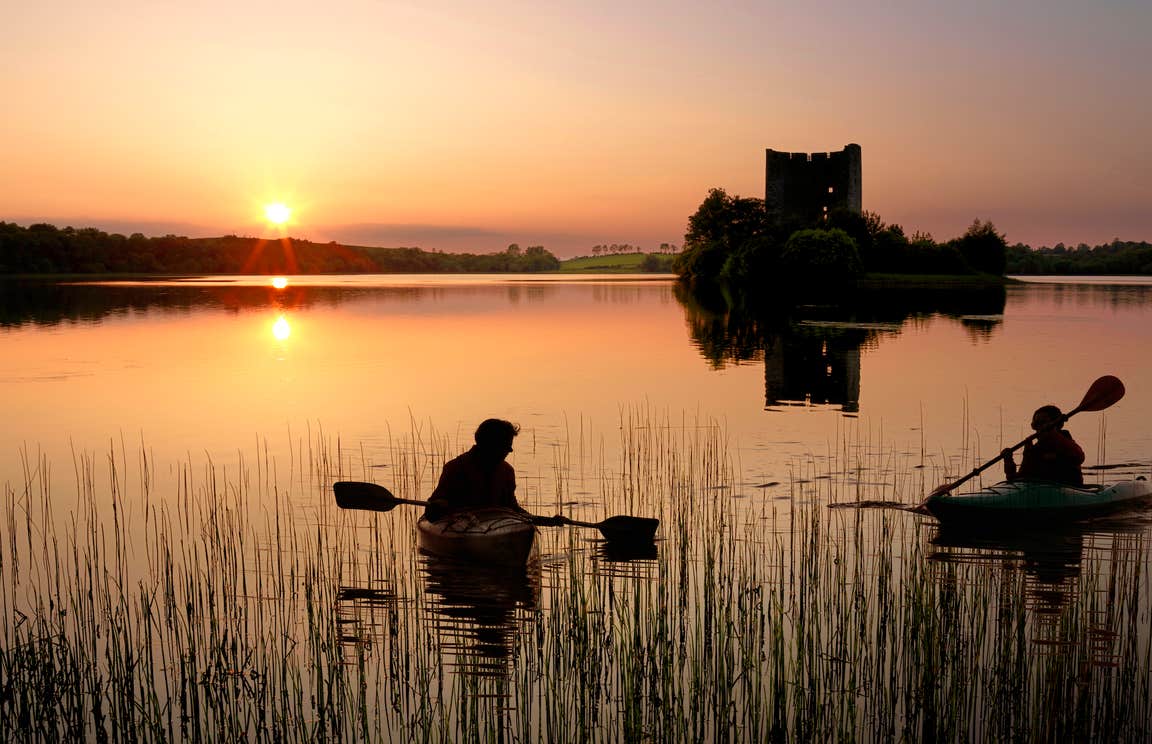 People kayaking in Lough Oughter, Co Cavan at sunset
