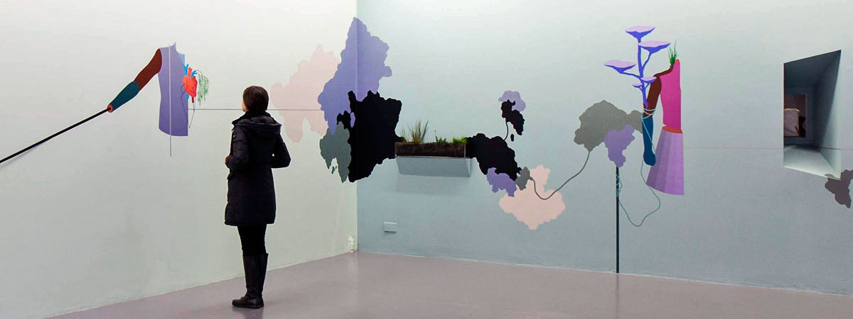A person admiring some wall art in the gallery