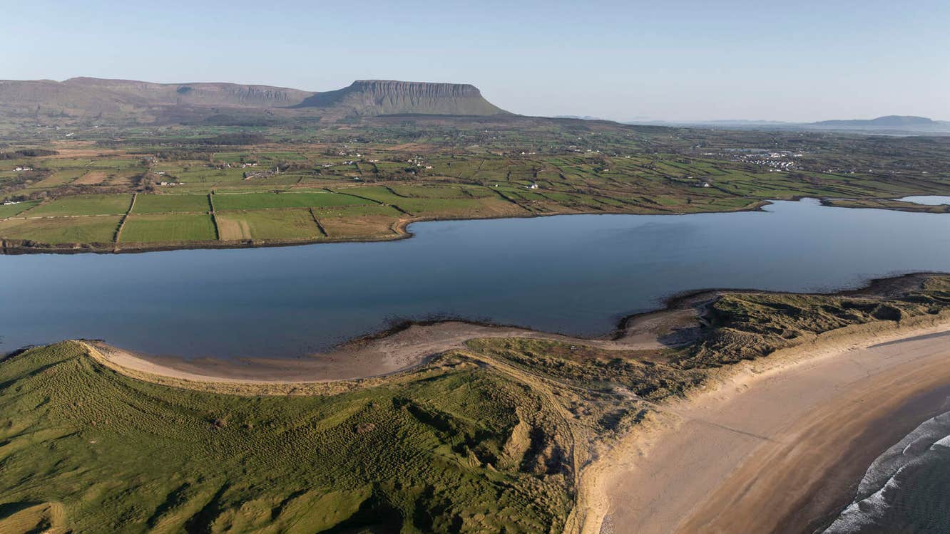 Aerial view of a beach and sea with Benbulben overlooking it